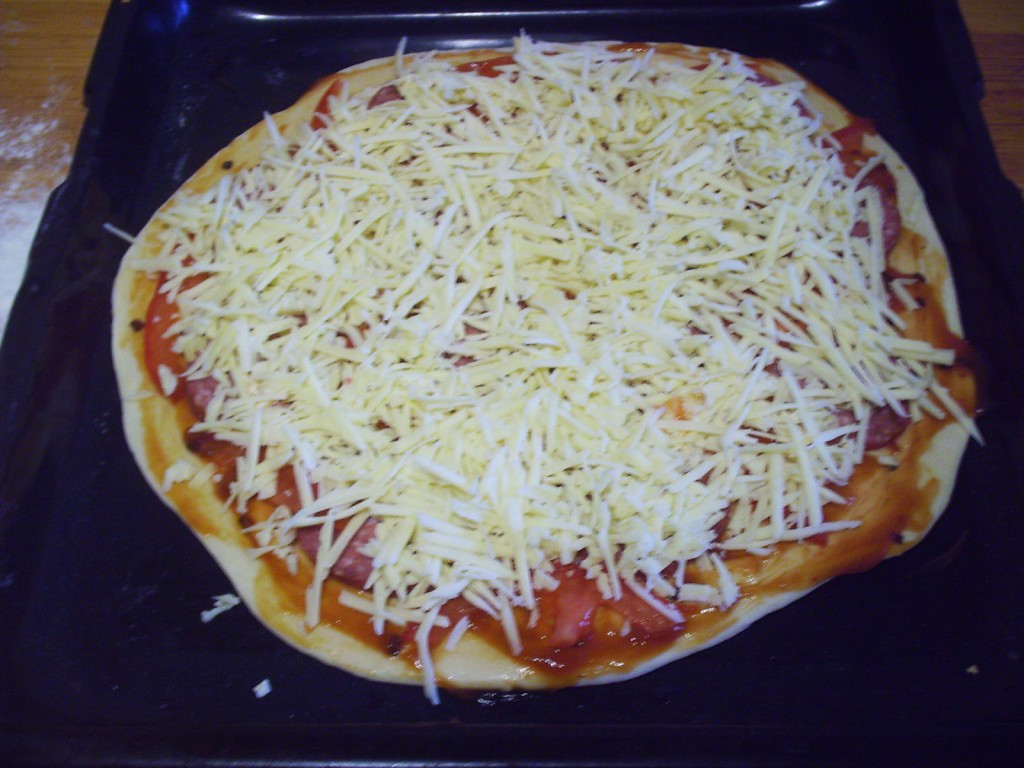 Пицца с копченной колбасой, помидорами и грибами