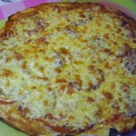 Пицца с копченной колбасой, помидорами и грибами